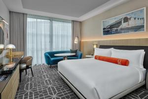 una habitación de hotel con una cama grande y una silla en The Crescent Hotel, Fort Worth en Fort Worth