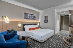 a hotel room with a bed and two blue chairs at The Crescent Hotel, Fort Worth in Fort Worth