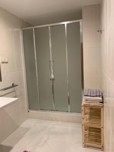 a glass shower in a bathroom with a sink at charmant appartement a oran gambetta pour famille in Oran