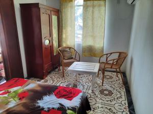 Habitación con cama, mesa y sillas. en Chez Madam Rose, en Le Morne