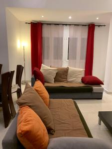 uma sala de estar com um sofá e cortinas vermelhas em charmant appartement a oran gambetta pour famille em Orã