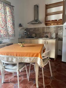 a kitchen with a table and two chairs and a kitchen with a refrigerator at DONNA FELICIA in Pachino +15 photos