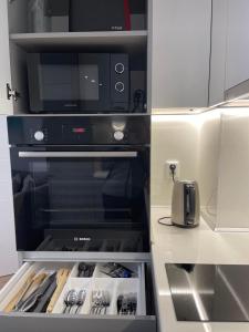 a kitchen with an oven with a microwave at Nova City Apartments in Varna City