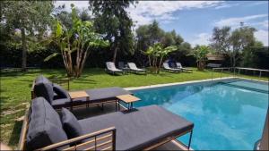 Enervillas VIP Villas with pool bbq في Káto Alissós: مسبح بجانبه طاولة وكراسي