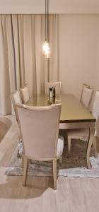 een eettafel met witte stoelen en een tafel en een stoel bij Breeze 2 in Dubai