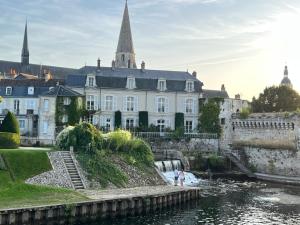 um grande edifício branco ao lado de uma massa de água em Terrasse coeur de Vendôme Caroline Paul Officiel em Vendôme