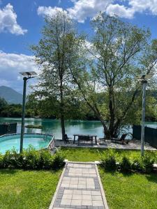 a swimming pool with a picnic table and a lake at Apartman Azul in Podastrana