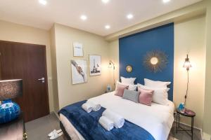 a bedroom with a large bed with a blue accent wall at Sweet Inn - Rue Duret in Paris