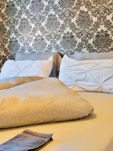 uma cama com duas almofadas com uma parede em apartment ALUB em Bischofshofen