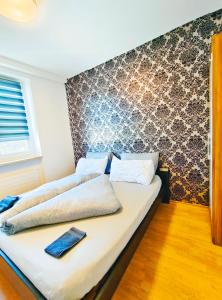 Ce lit se trouve dans une chambre dotée d'un mur. dans l'établissement apartment ALUB, à Bischofshofen