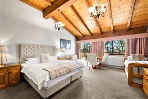 a bedroom with a bed and a table and chairs at Hotel Pension Grimus in Mount Buller