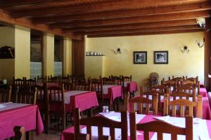 un comedor con mesas y sillas con mantel rosa en Hotel Rantiner, en Taüll