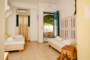 a bedroom with two beds and a door to a balcony at Fanari Art in Ios Chora +37 photos