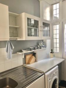 a kitchen with white cabinets and a sink and a dishwasher at Entire Cottage Style flat in heart of Wallingford in Wallingford