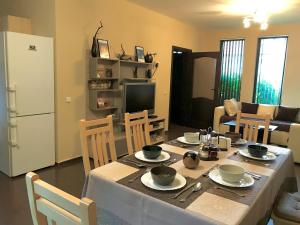 comedor con mesa con sillas y TV en Villa Dimi, en Sinemorets