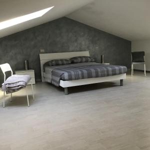 1 Schlafzimmer mit einem Bett und 2 Stühlen in der Unterkunft L olivo in Lucca