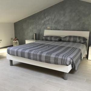 1 dormitorio con 1 cama grande con manta a rayas en L olivo, en Lucca