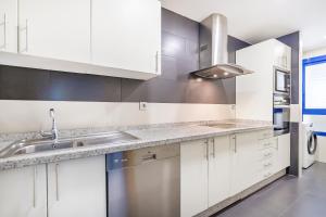 a kitchen with white cabinets and a sink at BHost - Pacífico in Málaga