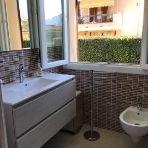 baño con lavabo y aseo y ventana en L olivo, en Lucca