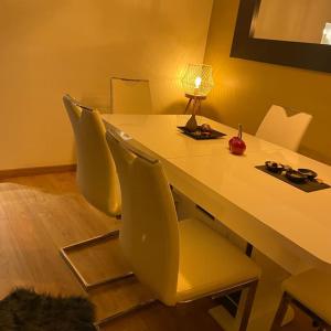 mesa de comedor con sillas amarillas y lámpara en Appartement cosy Noisy le sec, en Noisy-le-Sec
