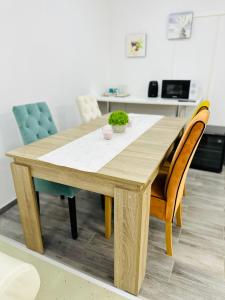 una mesa de madera y sillas en la sala de estar. en Carpe Diem Privat Guesthouse, en Hermina-major