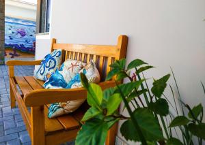 drewniana ławka z poduszkami i rośliną w obiekcie Pousada Mar de Luna w mieście Penha