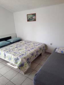 a bedroom with a bed with a floral bedspread at Apartmani na moru in Bar