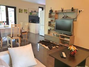 sala de estar con TV y mesa en Villa Dimi en Sinemorets