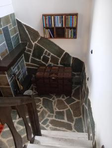 a room with a stone fireplace with a book shelf at Ξενωνας Ασημακοπουλου in Diakopto