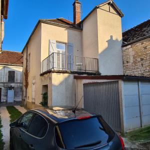 une voiture noire garée devant une maison dans l'établissement Alba - terrasse, local à vélos et parking au centre historique, à Tonnerre