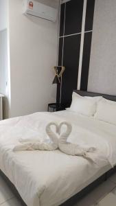 a heart shaped towel on a bed in a bedroom at Horizon Suites Ezhome in Sepang