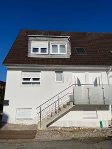uma casa branca com uma escada em frente em Schickes 110qm Ferienhaus in Nähe VW, DEZ und Orangerie em Kassel