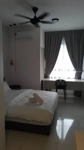 sypialnia z łóżkiem i wentylatorem sufitowym w obiekcie Horizon Suites Ezhome w mieście Sepang