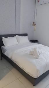 a white bed with a stuffed animal on top of it at Horizon Suites Ezhome in Sepang