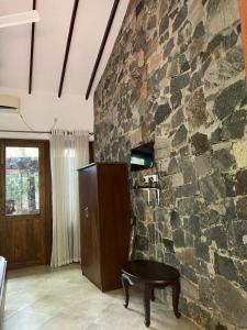 a stone wall with a table in front of a room at Twin Blocks Nature Resort in Anuradhapura