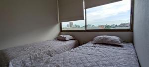 2 camas individuales en un dormitorio con ventana en Acogedor departamento 2 Habitaciones y 2 baños Santiago de Chile, en Santiago