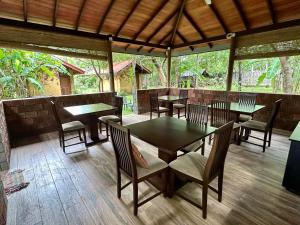 einen Essbereich mit Tischen und Stühlen in einem Pavillon in der Unterkunft Sat Nam Village Eco-Hotel in Sigiriya