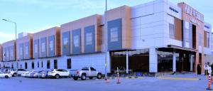 a large building with cars parked in a parking lot at Art Suite in Riyadh