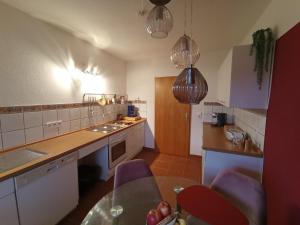 a kitchen with a counter and a table in it at Hochparterre mit Balkon und Gartenblick - Elisabeth von Berg in Rottweil +16 photos
