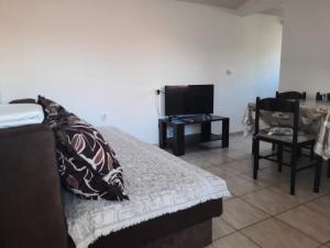 a bedroom with a bed and a tv and a table at Apartmani na moru in Bar