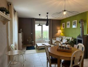 ein Wohnzimmer mit einem Tisch und einem Sofa in der Unterkunft L'Intemporel in Cernay-lès-Reims
