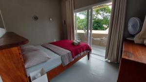 Habitación pequeña con cama y ventana en Monkey beach agroturismo, en Gamboa