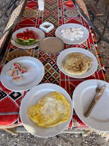 a table with white plates of food on it at Blend in Nature Camp in Sharm El Sheikh