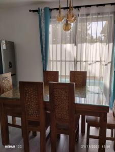 una sala da pranzo con tavolo in vetro e sedie di Garuda Villa a Trou aux Biches