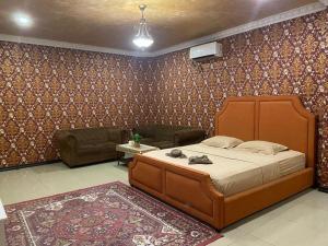 a bedroom with a large bed and a couch at New Z Suites in Sunggal