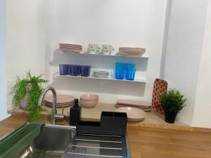 a kitchen with plates and bowls on shelves at SOTAVENTO La Solera in Sanlúcar de Barrameda