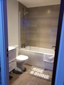 a bathroom with a tub and a toilet and a sink at Luxury 9ine Beautiful Bull Ring Apartment Free Parking in Birmingham