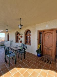 patio con mesa, sillas y puerta en Villa los Dulces-Piscina Privada, en Letur