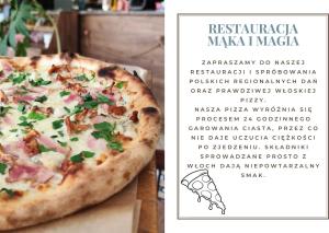 eine Pizza auf einem Tisch neben einem Menü in der Unterkunft Mąka i Magia Obiady domowe Hotel in Zambrów