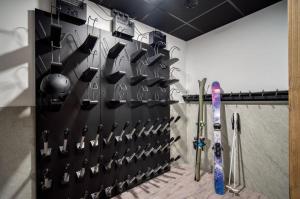 une chambre dotée d'un mur rempli de matériel de ski dans l'établissement Lodge des Glaciers, à Montvalezan